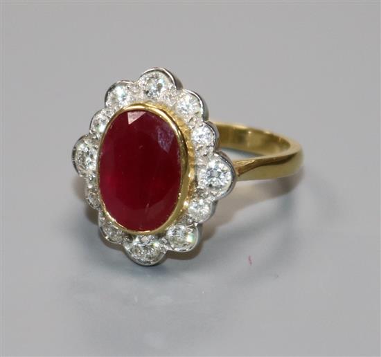 A modern 18ct gold, ruby and diamond oval cluster ring, size N.